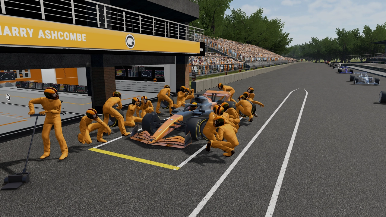 Pit crew in matching yellow suits and helmets surrounding their car in the pit lane.